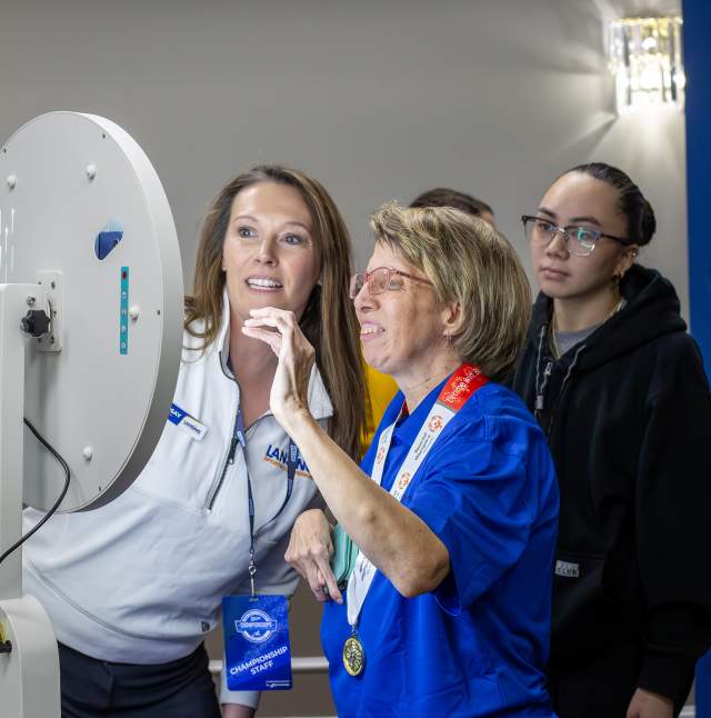 Lindsay Fast is helping a participant set up the selfie station at the NAIA National Championship