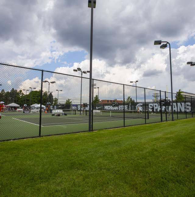 Wide shot of two tennis players playing on an outside tennis court