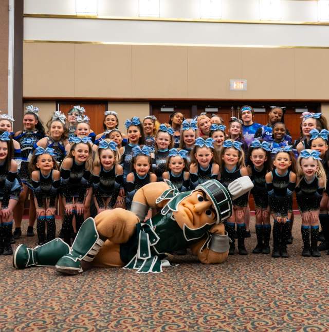 Sparty posing with a group of dancers from the EPIC! Cheer and Dance Championships
