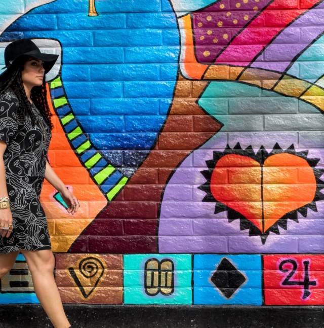 Woman Walking in Front of Mural