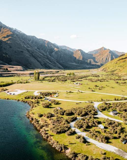 Birdeye view of lake with green landscape and mountains in the background