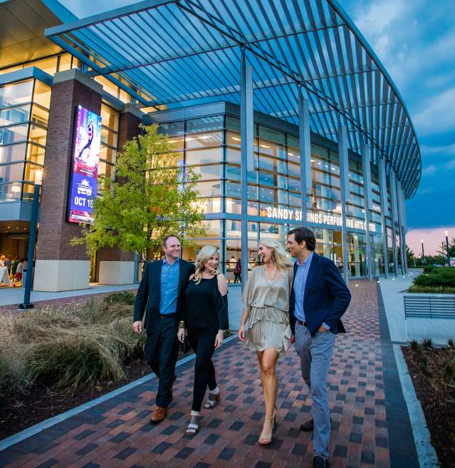 Couples walking in front of the Sandy Springs Performing Arts Center at City Springs.