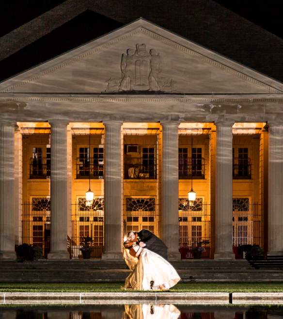 groom kissing his bride outside the hall of springs at night