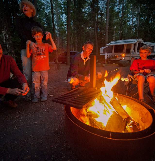 Family roasting smore over campfire