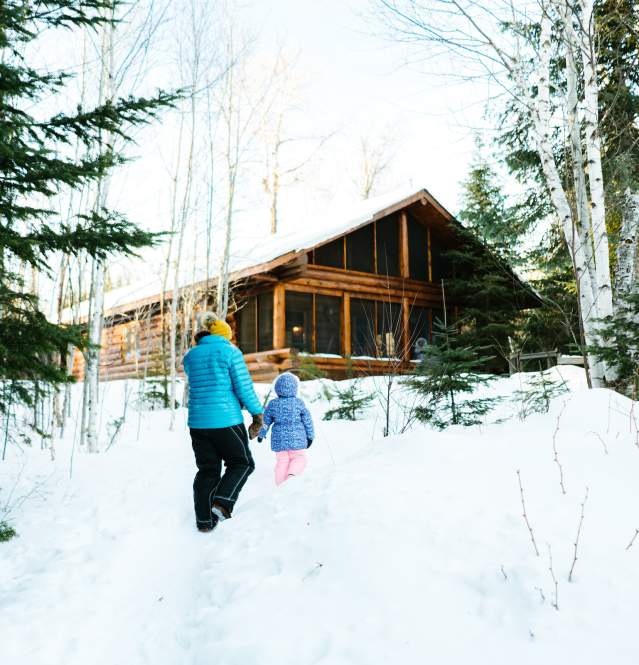 Winter cabin with family outside on Gunflint Trail