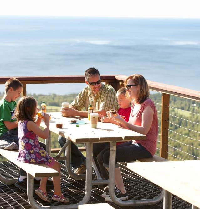 Family enjoying breakfast at outdoor picnic table
