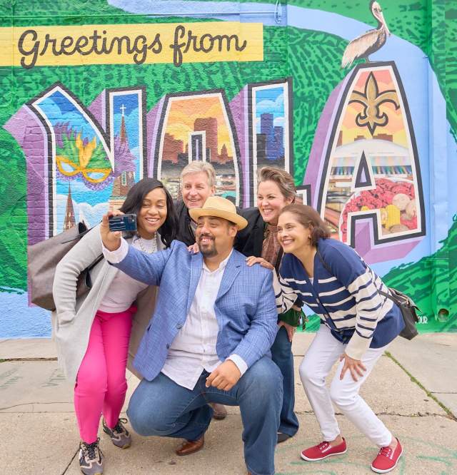 Sightseeing on Magazine Street in front of the Greetings from NOLA mural
