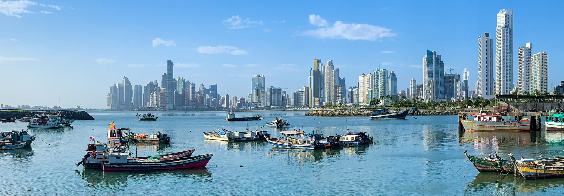A picture of the panama city scape behind people in their boats.