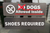 A business sign at Goldens in Golden CO 2025 with the NO crossed so it says DOGS Allowed Inside and Shoes Required for the event