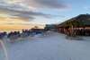 Sunset Beach Club view of dry beach, tiki hut, water, and sunset