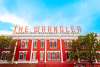 A photo of the red and white brick building with the famous "The Wrangler: Famous for Ranchwear Since 1934".