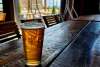A glass of craft beer sitting on a rustic wooden table at Westby Edge Brewing, one of the best spots for craft drinks and local vibes, and a must-visit hidden gem and great for something to do in Cheyenne.