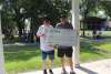 Two men, holding a check for third place at Ribfest.