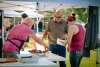 A man serving ribs to a man and a woman.