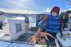 Lucas DeWitt with a tanner crab onboard the F/V Kealailani