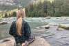Caught in the tranquility, girl on rock looking at the Chilkoot river