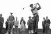 Man golfing with spectators in the background