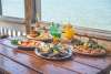 Seafood and colorful drinks with the water in the background