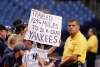 New York Yankees fan holding a sign reading "TRAVELED 1246 MILES TO SEE OUR YANKEES"