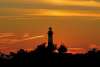 The Bodie Island Lighthouse backlit by an orange sky in Nags Head, NC