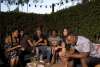Friends dining on a patio at dusk.