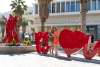 Couple in fron to PS I Love You sculpure out front of the Rowan Hotel.