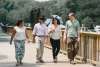 Two women and two women walking along a bridge