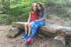 Two girls sitting together on a log