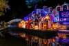 Nighttime river parade with parade float decorated with Dia de los Muertos decor