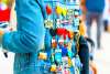 Back of person wearing jean jacket filled with Fiesta medals.