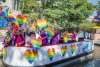 River barge with rainbow hearts and people floating on River Walk