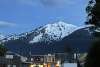 Late Alaskan night off Broadway's 5th Ave showcase gold rush era inspired false front buildings under snow covered mt harding and partly cloudy blue skies
