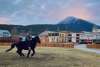 Enjoying cantering through Skagway with historic buildings, snow-capped mountains, and breathtaking sunset in the background.