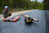 fly fishing line and tackle on a flat surface set in front of a fisherman tying a line