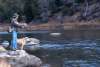 A person enjoying fly fishing in Saratoga, Wyoming with their loyal dog by their side, one of the many exciting things to do in the area.