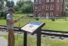 a man taking a photo of the Civil War Trails Marker located at Hanover Junction along the Heritage Rail Trail