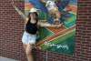Annelise Vuono posing with her handpainted mural inside WellSpan Park