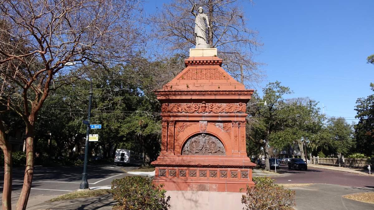 The terracotta Gayarre Place monument on Esplanade Avenue, framed by live oaks