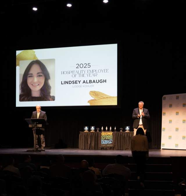 Two people on stage at meyer theater presenting awards
