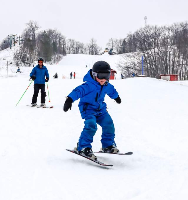 Child ski's at Mt. Ashwabay in Bayfield, Wisconsin on a snowy winter day.
