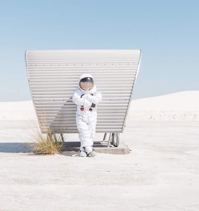 An astronaut leaning against a sun shade at White Sands National Park