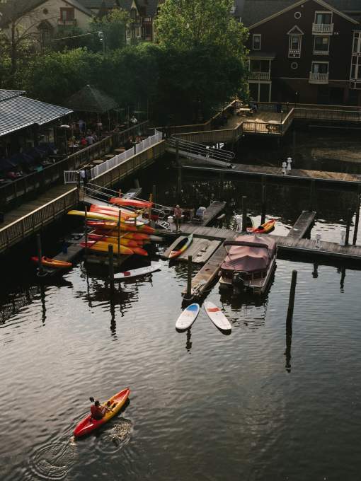 A boardwalk with kayaks and a few pontoon boats