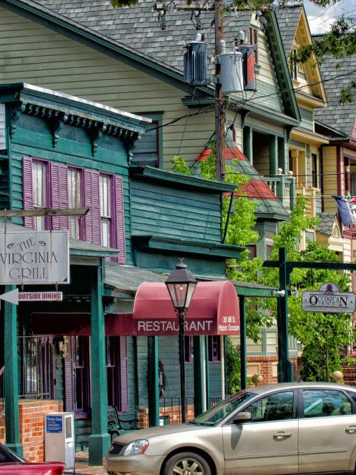 Colorful historic storefronts with cars parked outfront