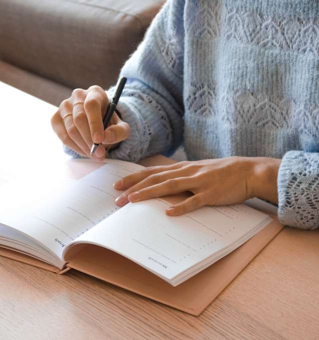 Woman writing in agenda