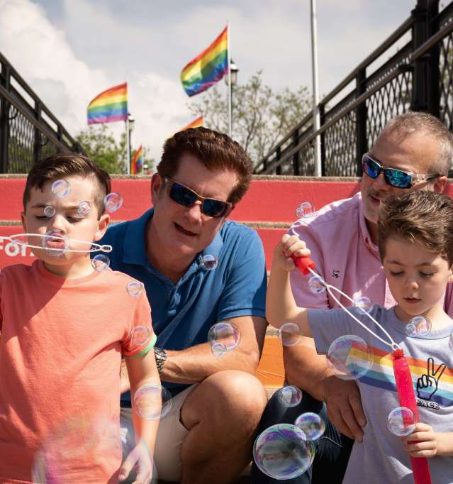 Family blowing bubbles on Galena Country Pride Bridge