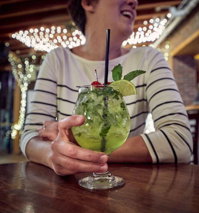 Woman holding cocktail in bar