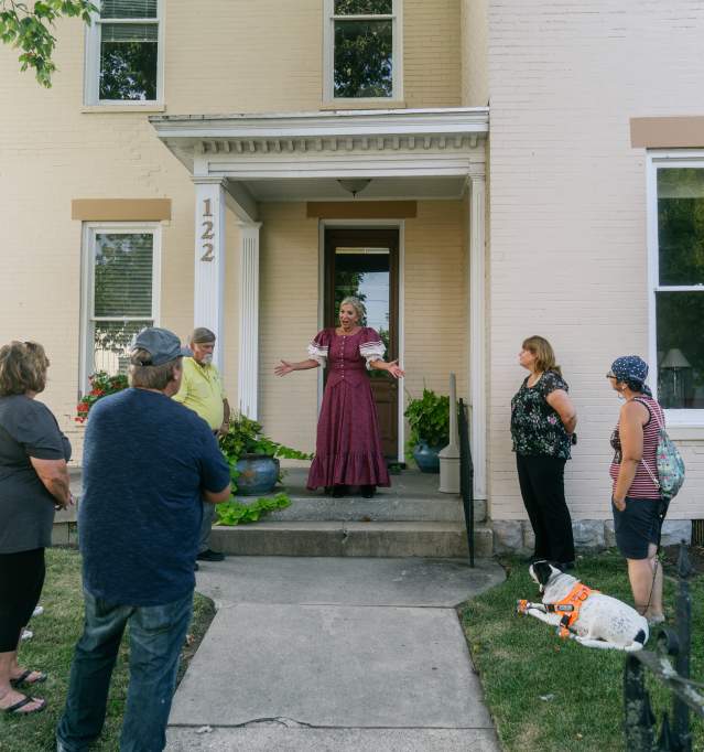 a person in period clothes speaking to participants of the historic walking tour