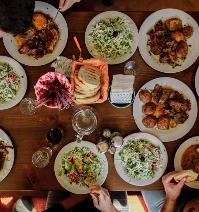 Table full of food that friends are gathered to eat at