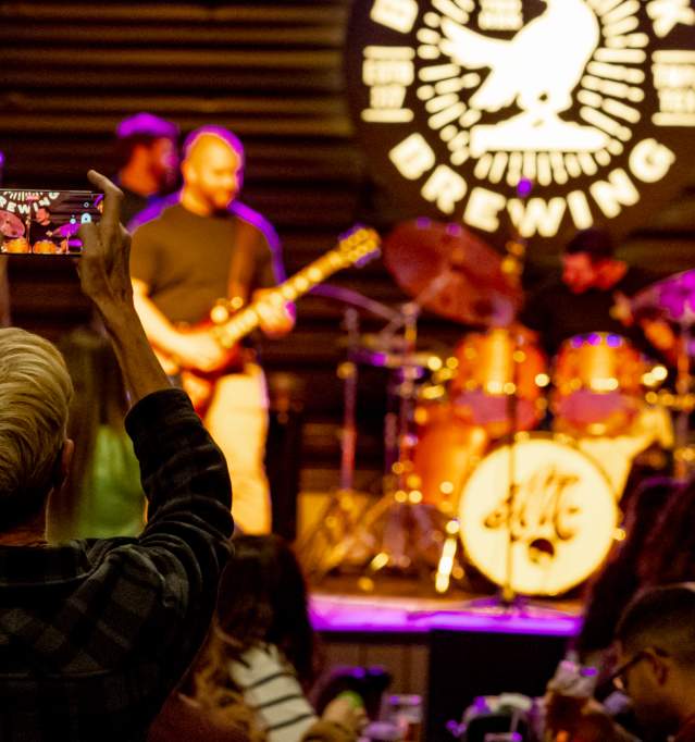American Merit performing at Bird Creek while woman films concert