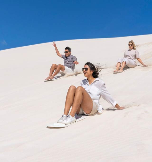 Group sand boarding on the dunes in Lancelin